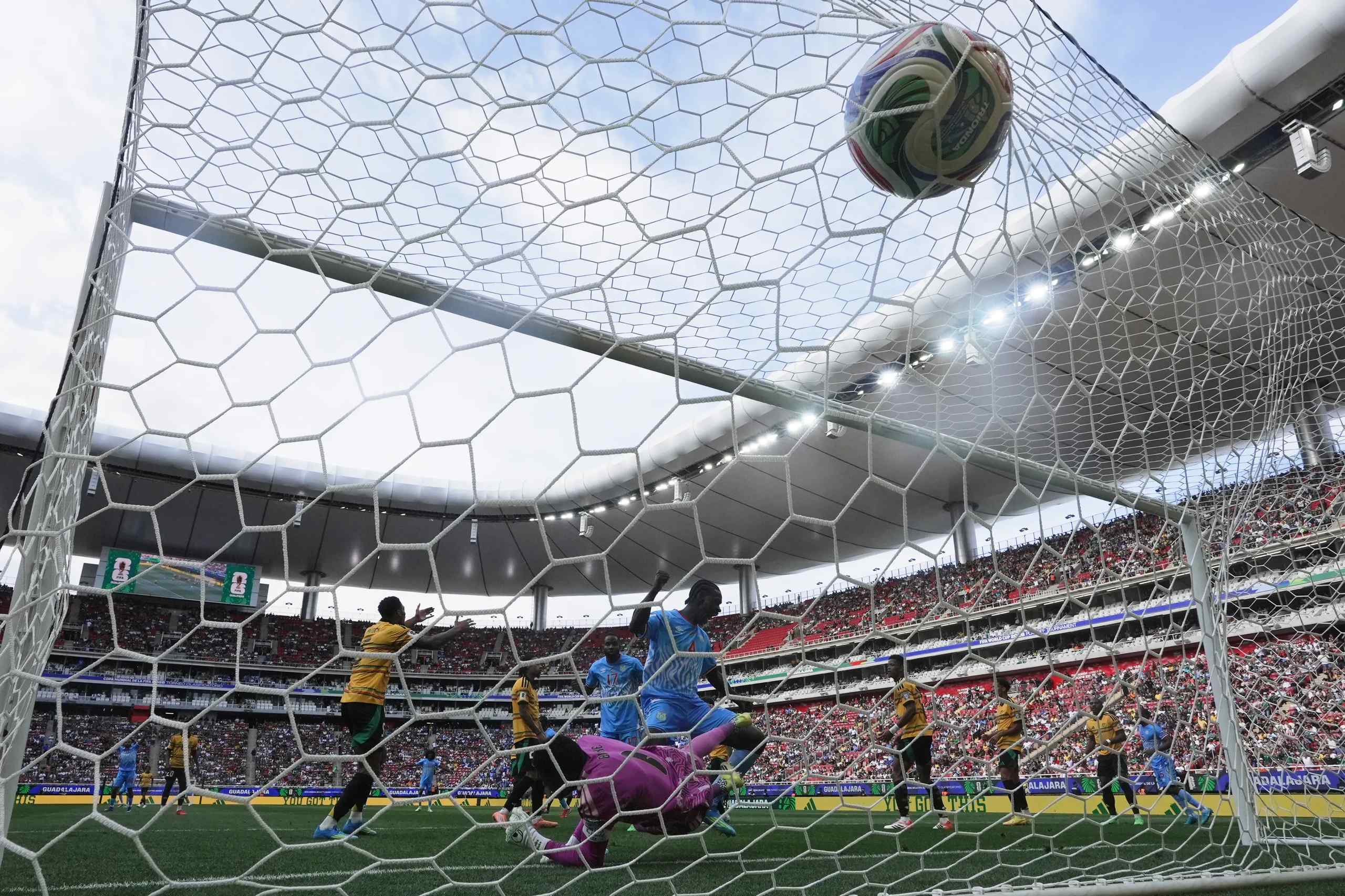 A soccer ball rippling the mesh of a net.
